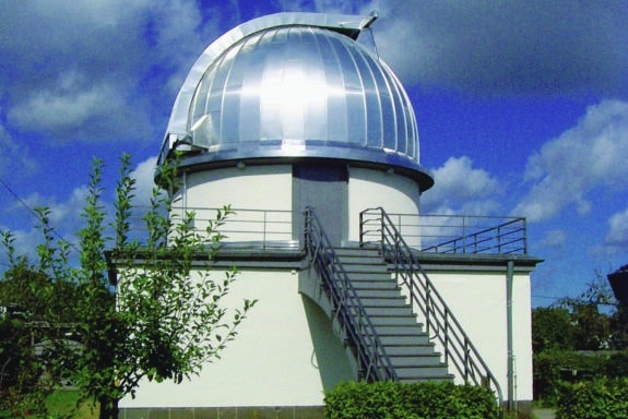 Die Kuppel hat einen Durchmesser von sechs Metern und zwei große Tore, die auf Stahlschienen rollen und über einen Kettenantrieb geöffnet und wieder geschlossen werden können. Von 2003 bis 2004 wurde sie mit Aluminiumblech eingedeckt. (Foto: Sternwarte_Aachen)